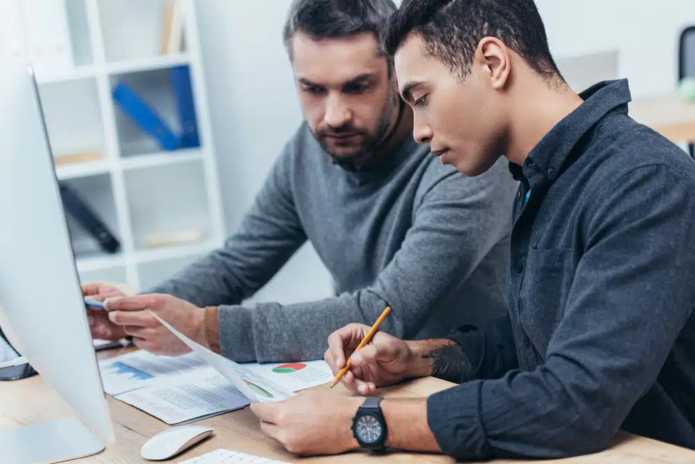 Two men working together at a desk